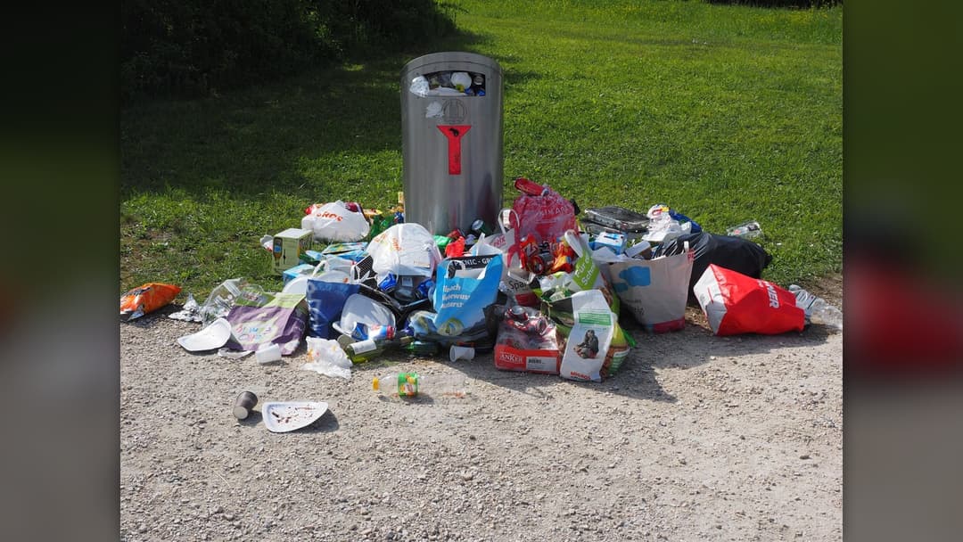 Outdoor household garbage cans stuffed with plastic trash bags