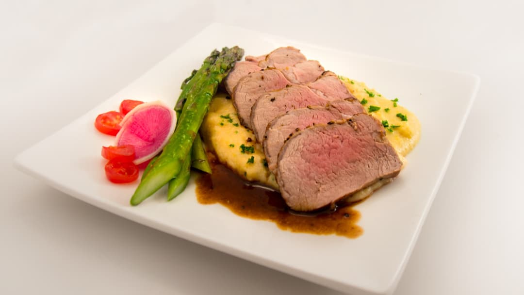 Succulent sliced roasted pork tenderloin on a serving plate