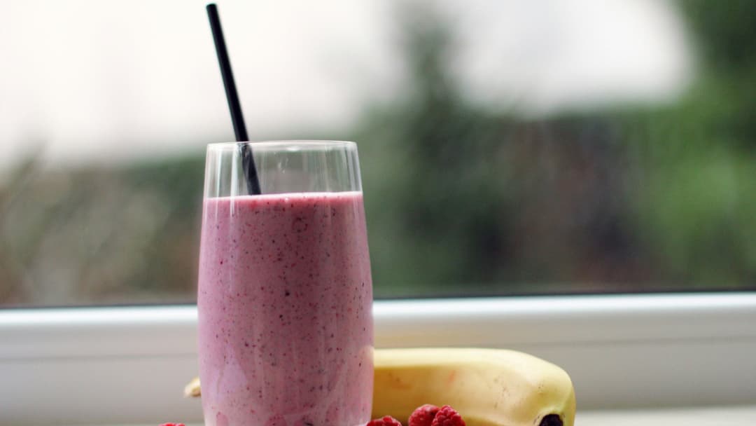 Protein smoothie shake served in a glass with fruit