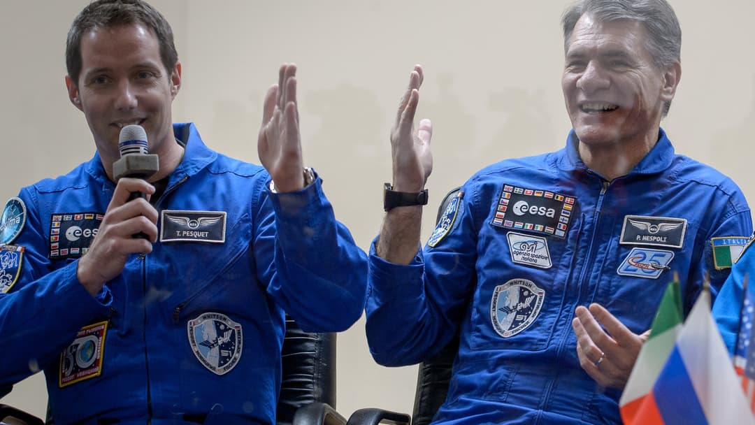 Expedition 50 astronauts speaking into microphones during a pre-launch press conference