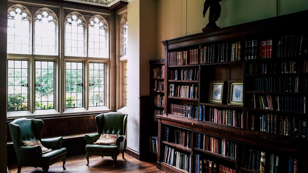 Stately wood-paneled private library room lined with floor-to-ceiling bookshelves