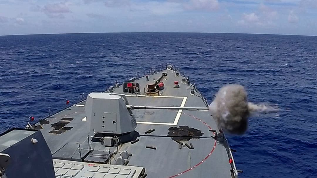 US Navy guided missile destroyer conducting a live fire exercise at sea