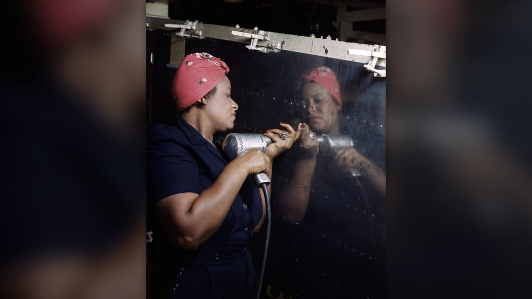 Wartime woman aircraft worker riveting an airplane assembly