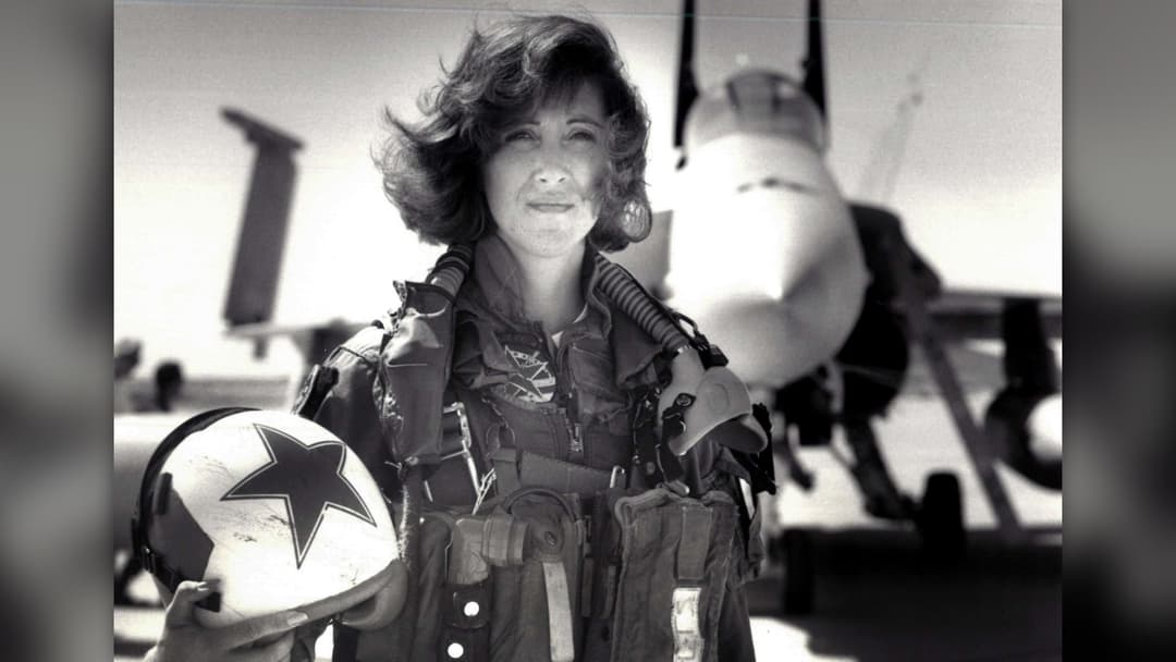 United States Navy fighter pilot Tammie Jo Shults standing in flight gear beside a Navy jet aircraft in 1992
