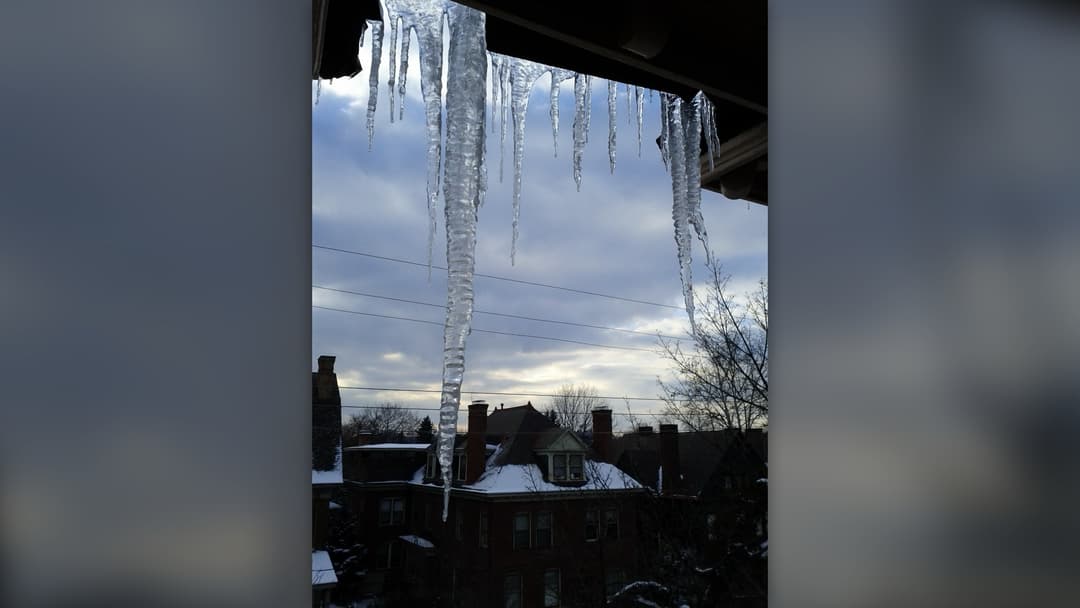 Winter ice and snow hanging from an attic roof in Pittsburgh, Pennsylvania