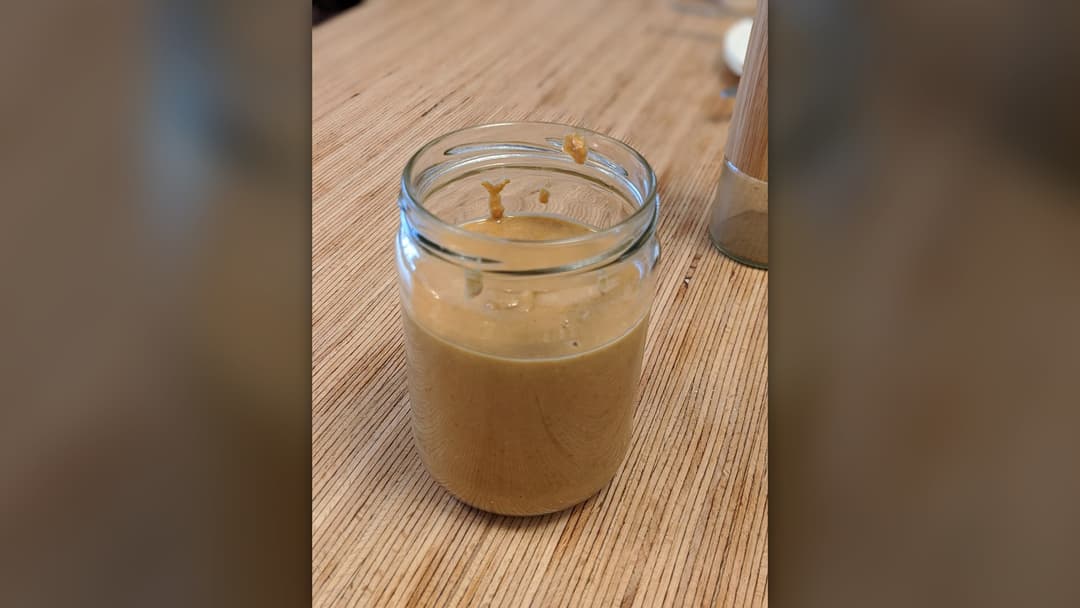 Glass jar filled with thick natural creamy peanut butter