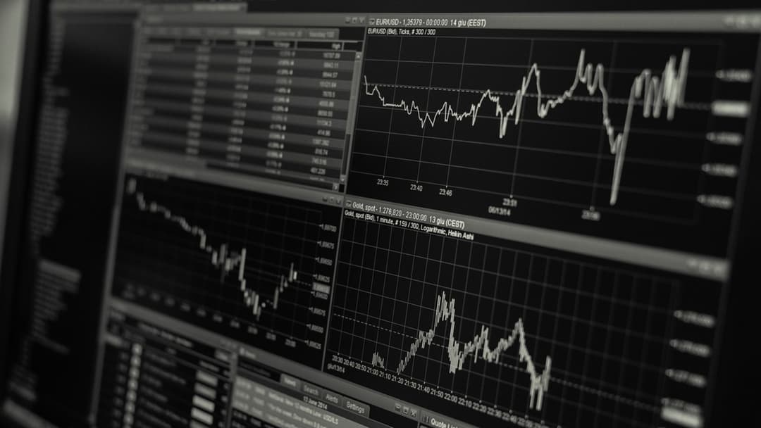 Financial market trading monitors displaying plunging stock and currency charts