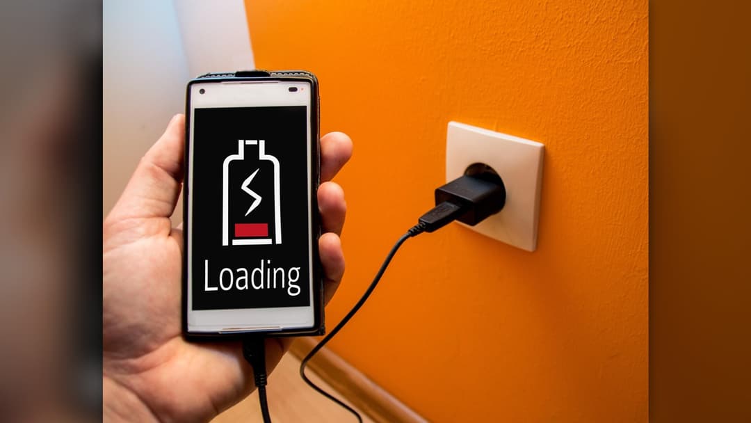 Smartphone plugged into a power charger on a table