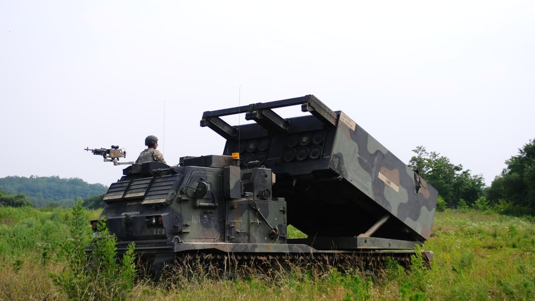 M270 Multiple Launch Rocket System firing a surface to surface missile in the field