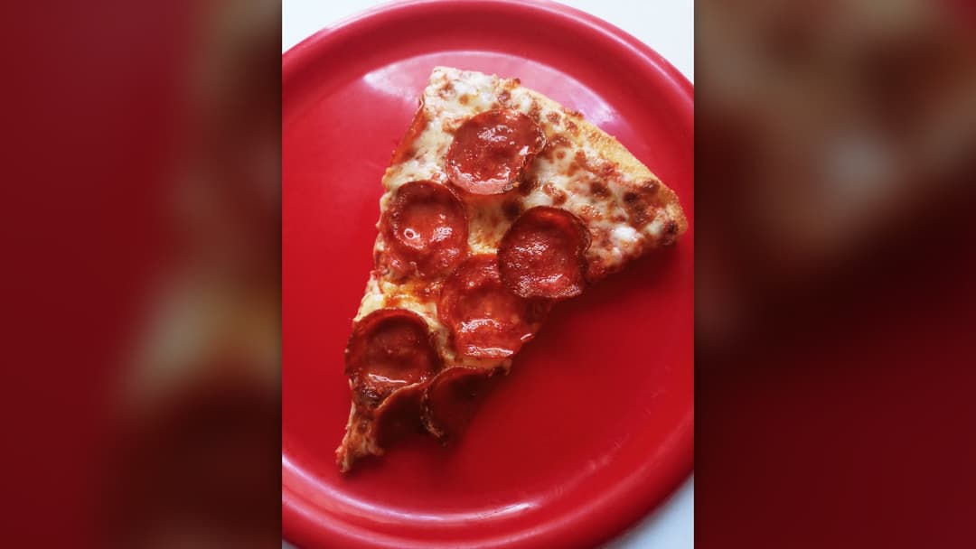 Hot slice of classic pepperoni pizza with melted cheese