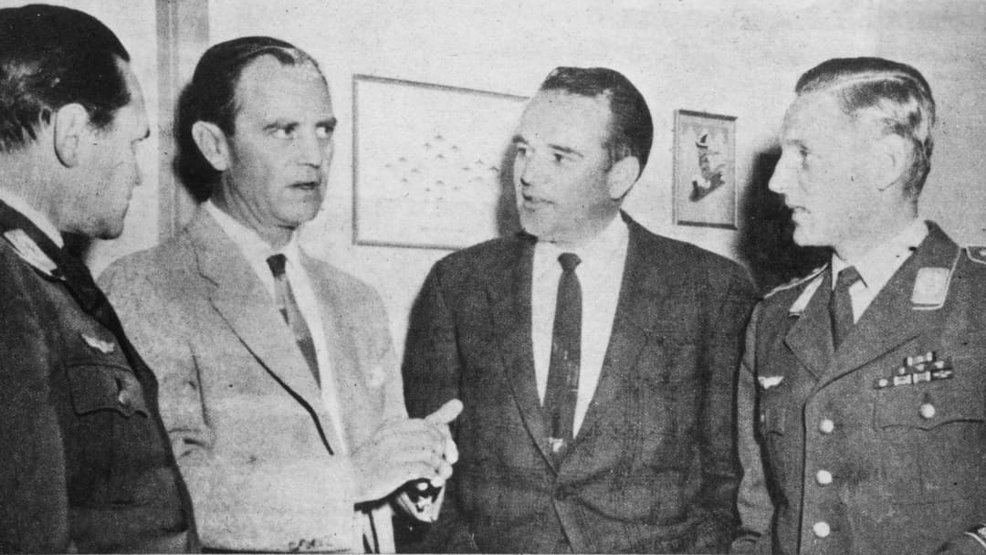 German flying ace Erich Hartmann discussing aerial tactics with fellow World War II fighter pilots in 1963