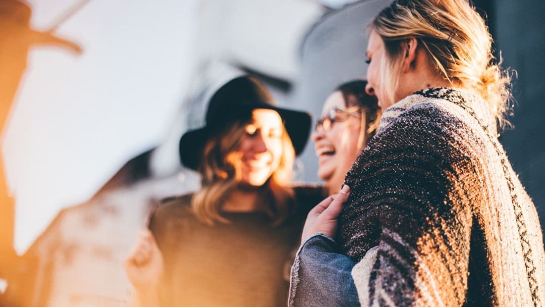 Landscape photograph of friends bursting into laughter together in relief