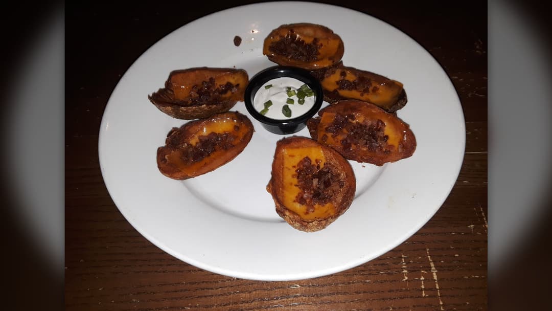 Crispy loaded potato skins topped with melted cheddar, bacon, and chives