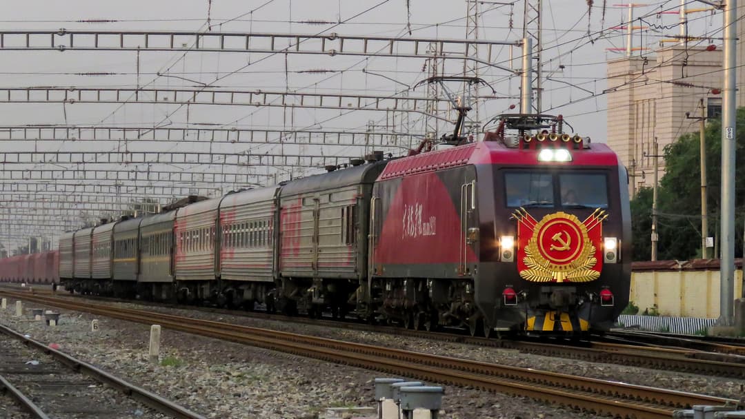 The Moscow to Beijing K20 Vostok Trans-Manchurian Express pulled by a red locomotive in China.