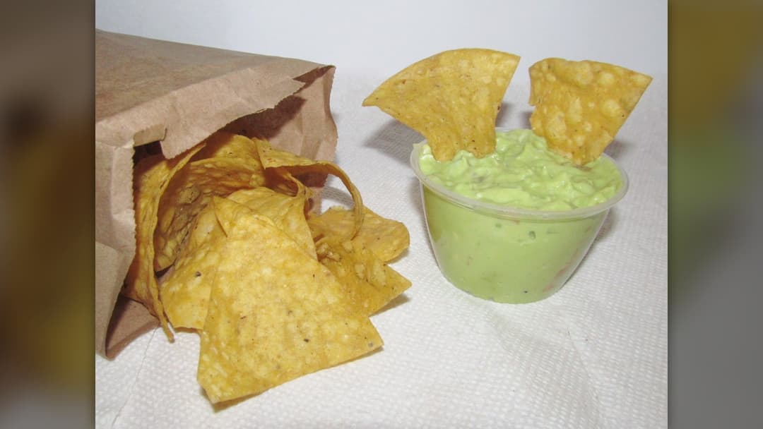 Fresh homemade guacamole served with salty crispy tortilla chips
