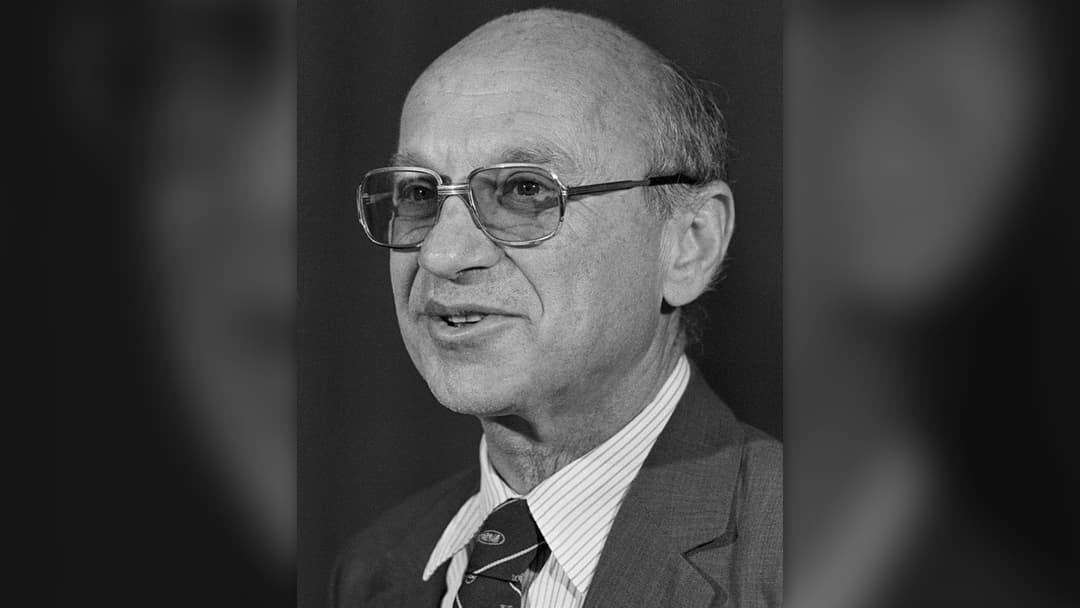 Economist Milton Friedman smiling in a 1976 news portrait