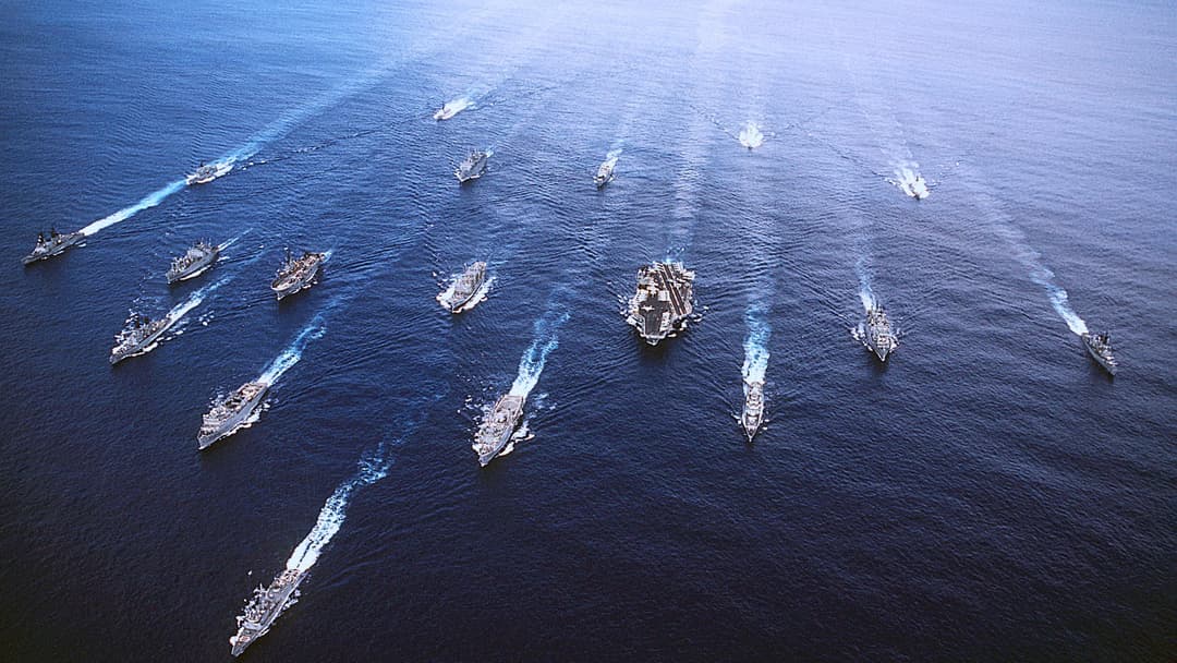 Aerial view of a US Navy aircraft carrier strike group underway in open ocean
