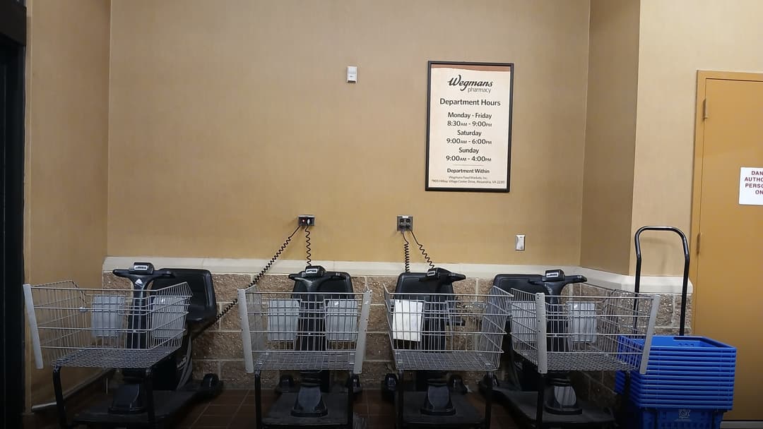 Fleet of motorized shopping carts charging at a grocery store.