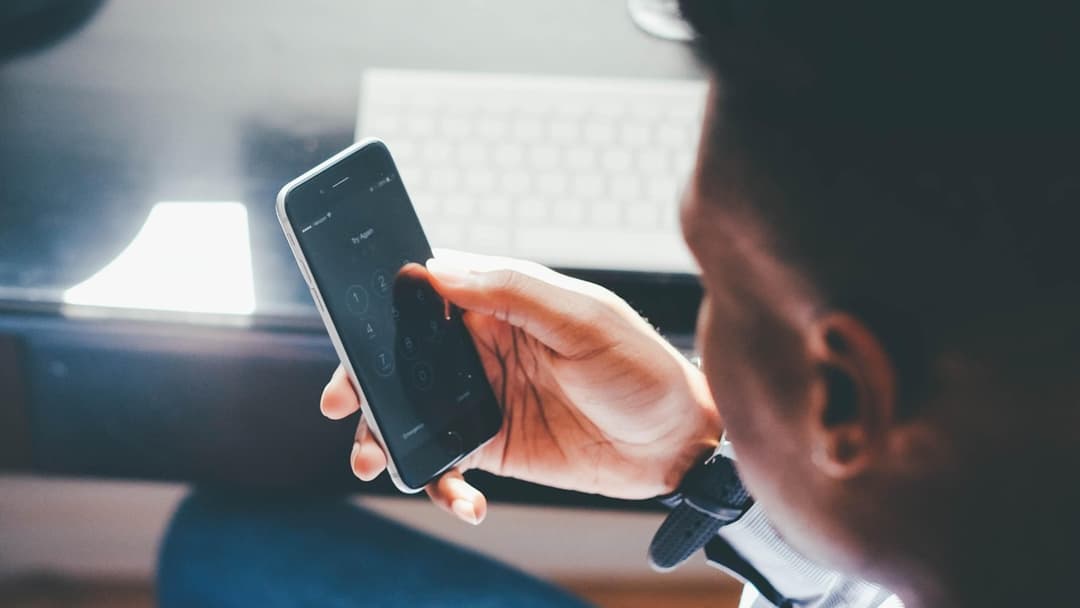 Person holding and operating a lagging mobile phone