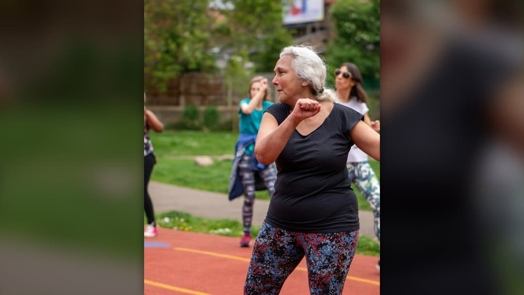 Active older adults exercising together in an outdoor conditioning class.