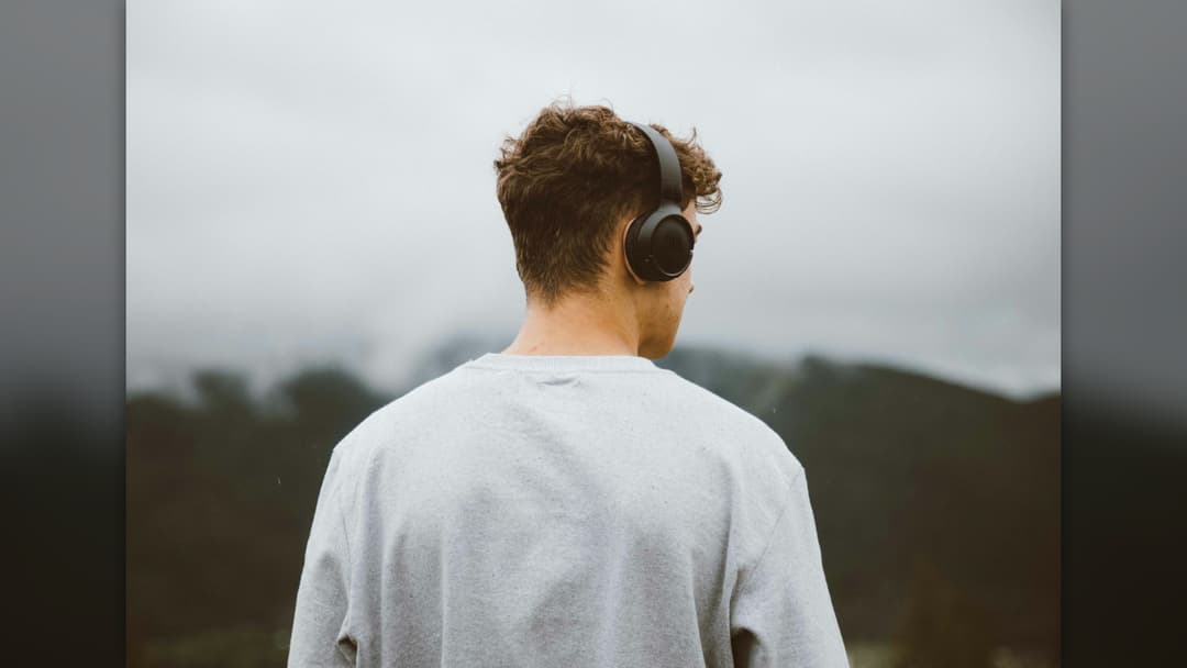 Listener wearing over-ear headphones outdoors