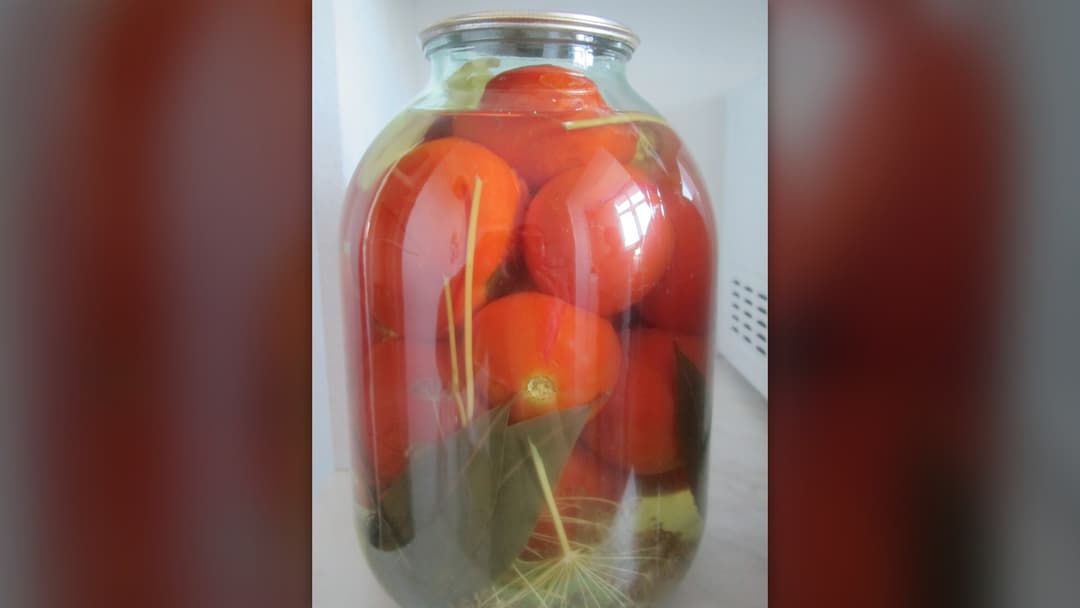 Jar of preserved whole canned tomatoes
