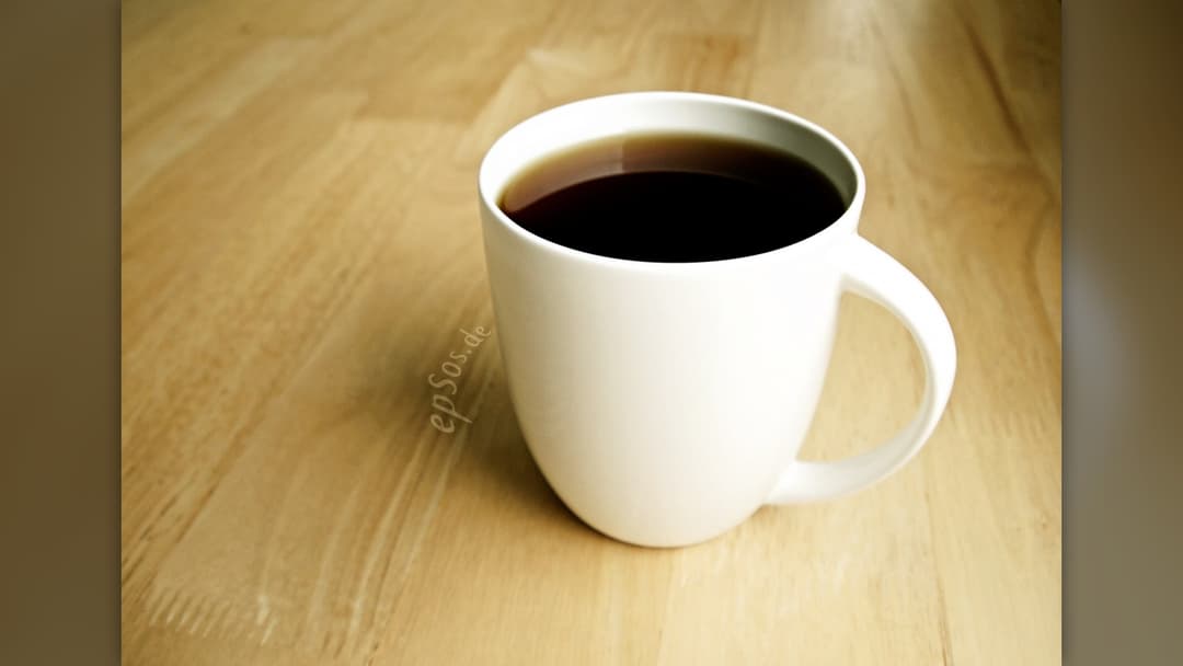 Freshly brewed hot black coffee in a white porcelain cup