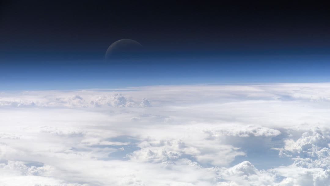 Curved horizon of Earth and the glowing blue upper atmosphere seen from space