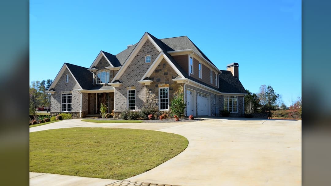 Grand limestone-clad luxury estate with symmetrical classical architecture and manicured grounds