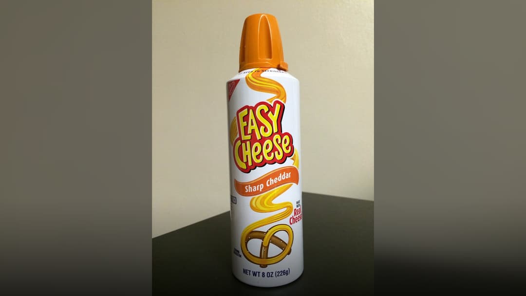 A yellow can of Kraft Easy Cheese Cheddar snack spread.