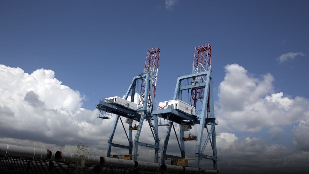 Heavy shipping container cranes and cargo infrastructure at the Port of Mobile, Alabama.