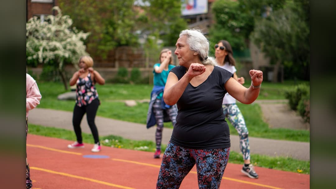 An active older woman engaged in outdoor fitness exercises maintaining strength and mobility.