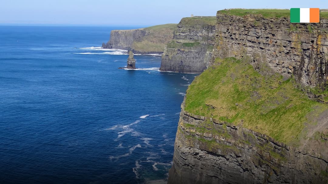The dramatic, emerald green Cliffs of Moher dropping sheer into the crashing Atlantic waves.