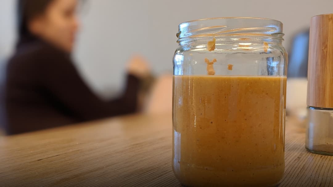 Glass jar of creamy peanut butter.