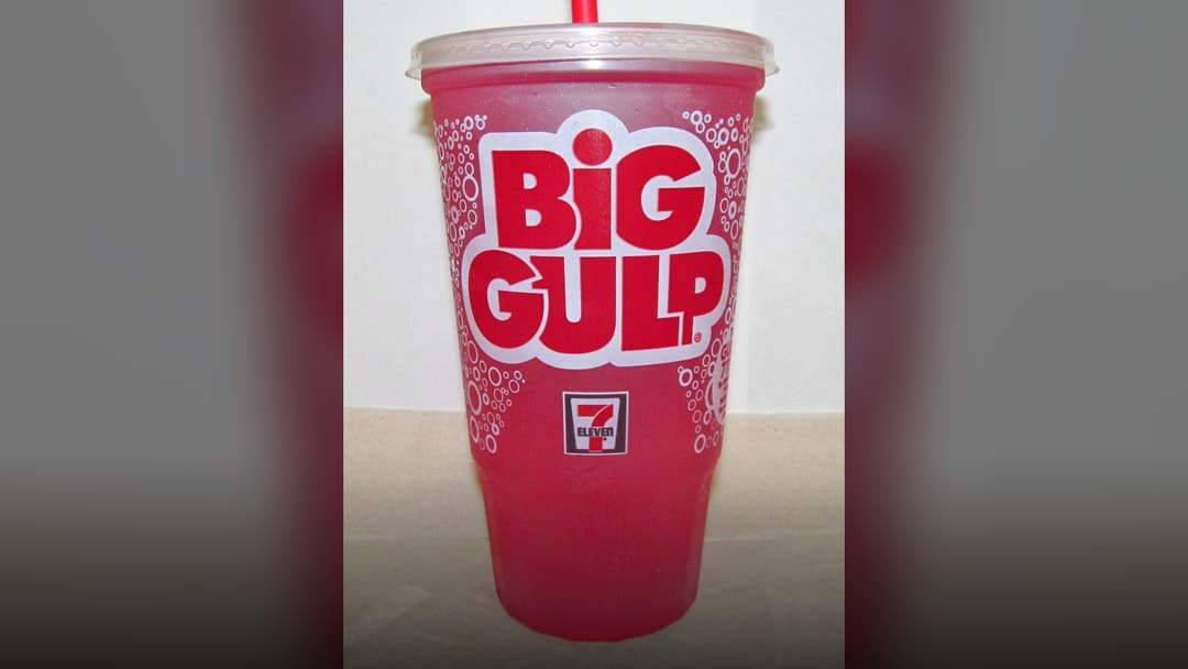 Large 7-Eleven Big Gulp fountain drink cup with straw.