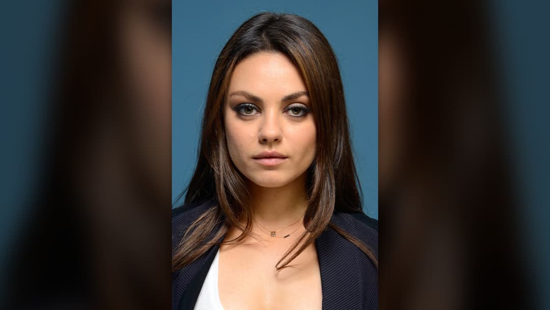 Actress Mila Kunis smiling during a panel discussion.