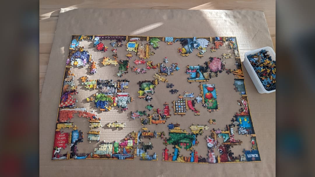 Partially completed jigsaw puzzle with unplaced pieces waiting to be resolved