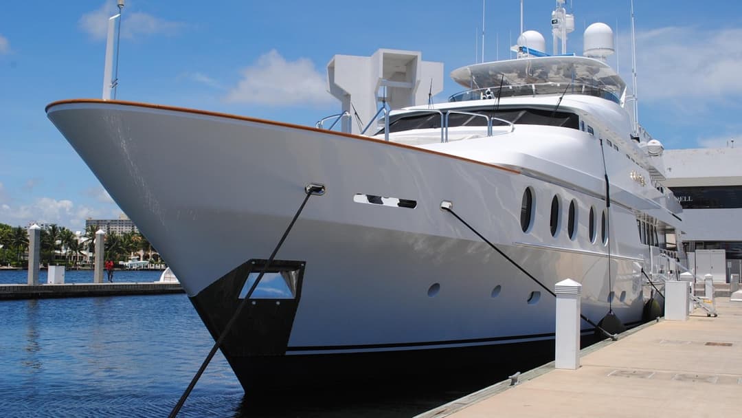 Multi-deck white superyacht moored along a private luxury dock in South Florida