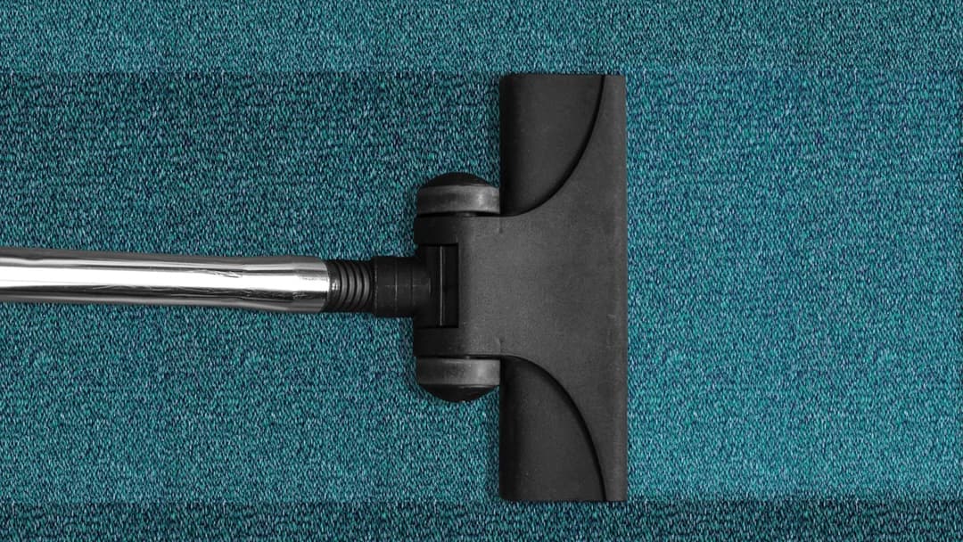 Vacuum cleaner nozzle cleaning a living room carpet