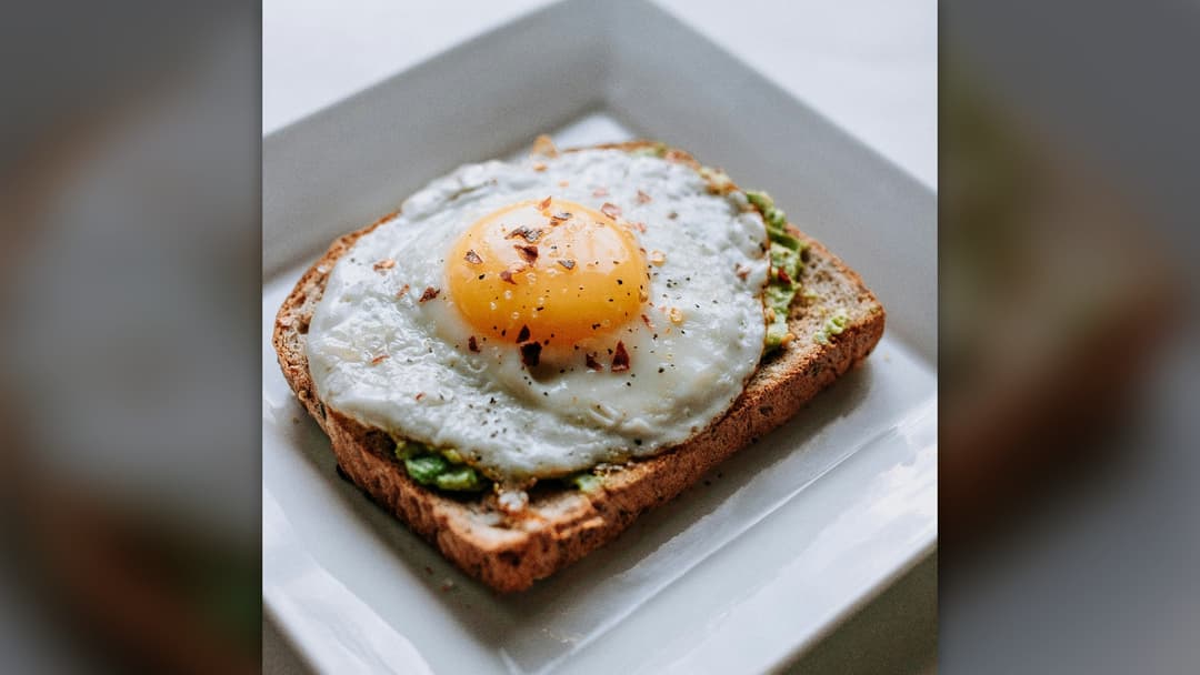 A nutritious breakfast plate featuring whole grain bread and a fresh sunny side-up egg.