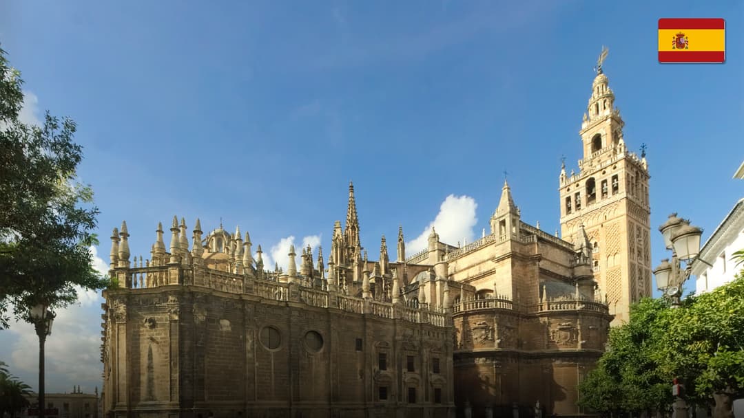 The monumental semi-circular Plaza de España complex with ornate bridges in Seville, Spain.