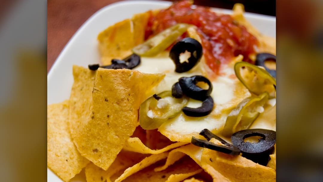 Loaded stadium nachos with warm cheese sauce and jalapeños
