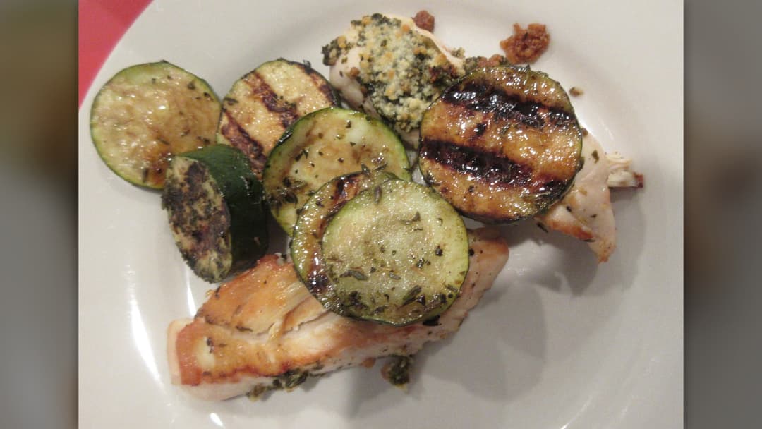 Grilled chicken breast served with roasted zucchini on a plate