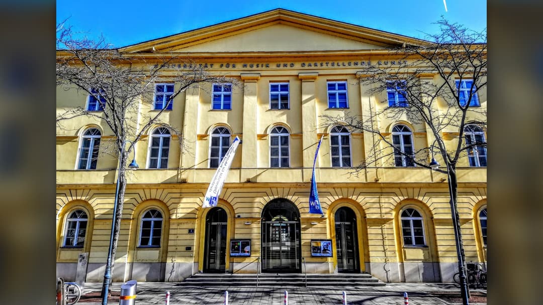 Imperial yellow neoclassical facade of the University of Music and Performing Arts Vienna in Austria
