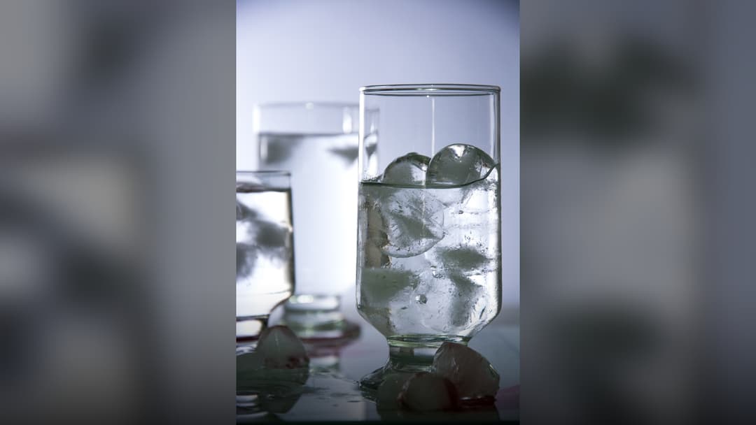 Glass filled to the top with clear ice cubes.