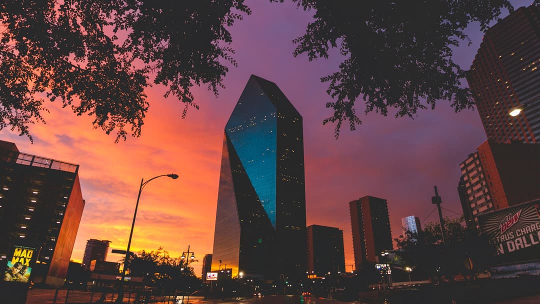 Downtown Dallas Texas skyline and Fountain Place Tower under a dramatic sunset sky