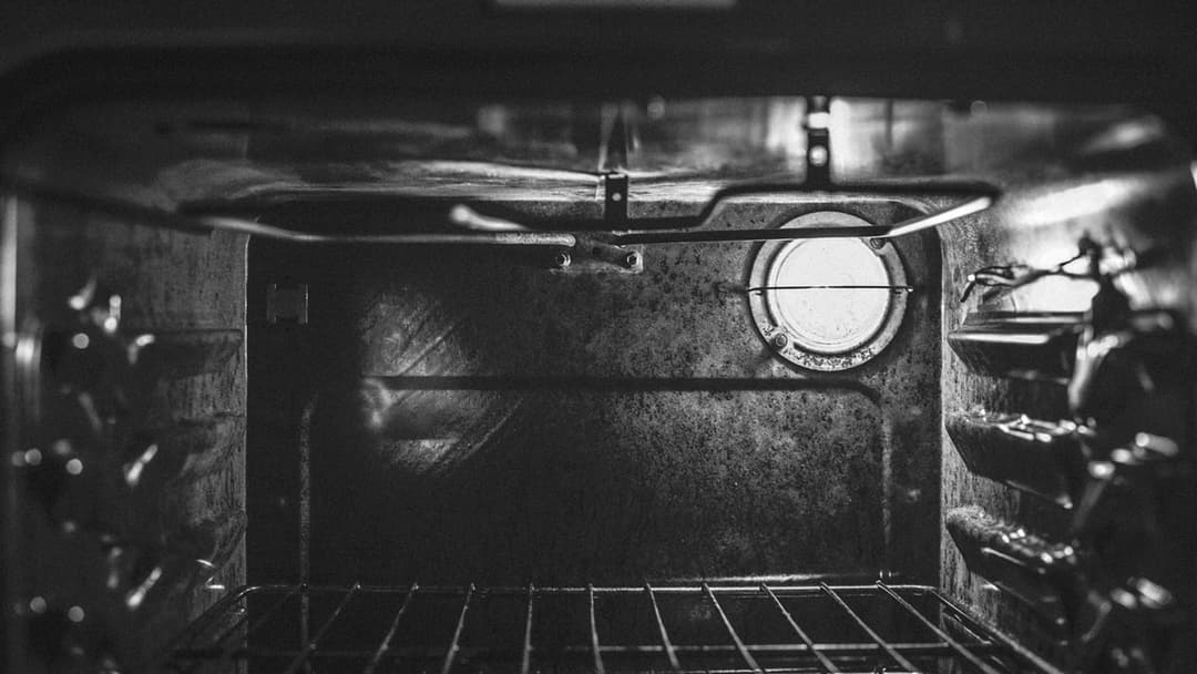 Open kitchen oven door showing metal baking racks inside