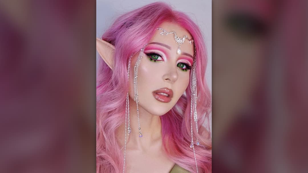 Close-up profile of sculpted doll-like lips and facial contour being styled with lip gloss