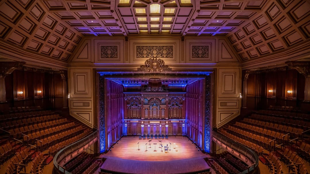 Gilded pipe organ and wooden stage inside Jordan Hall at the New England Conservatory in Boston