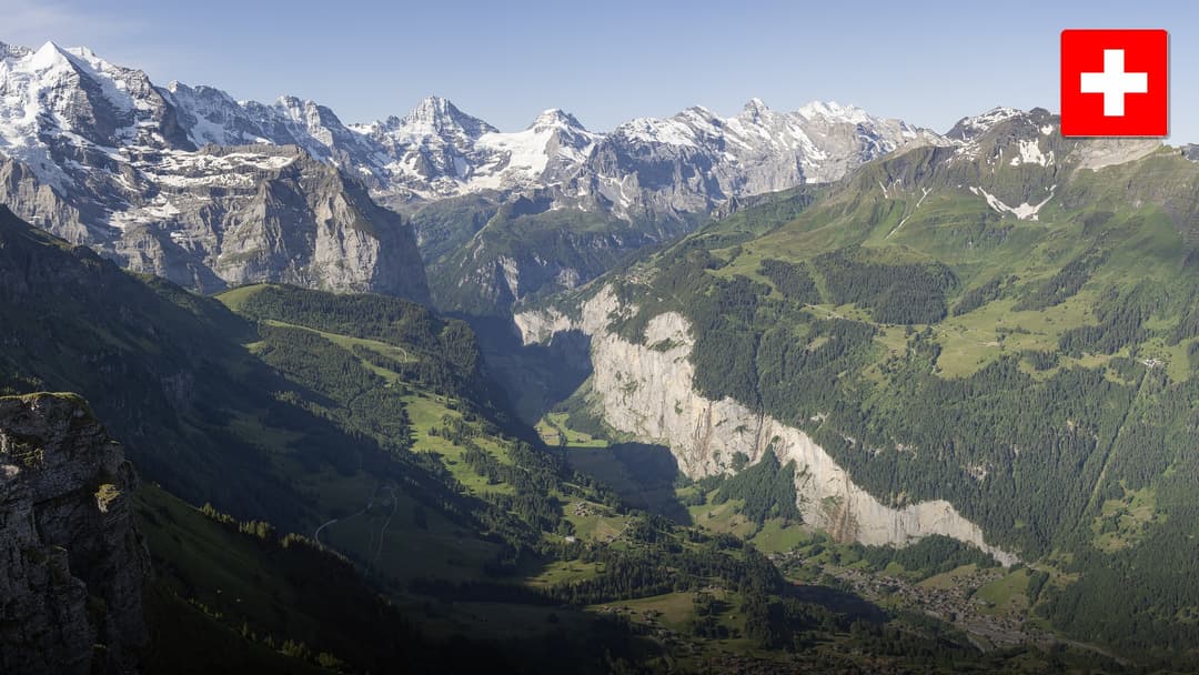 Staubbach Falls plunging from vertical alpine limestone cliffs over the chalet village of Lauterbrunnen.